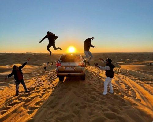 group jump in Dubai desert dune image